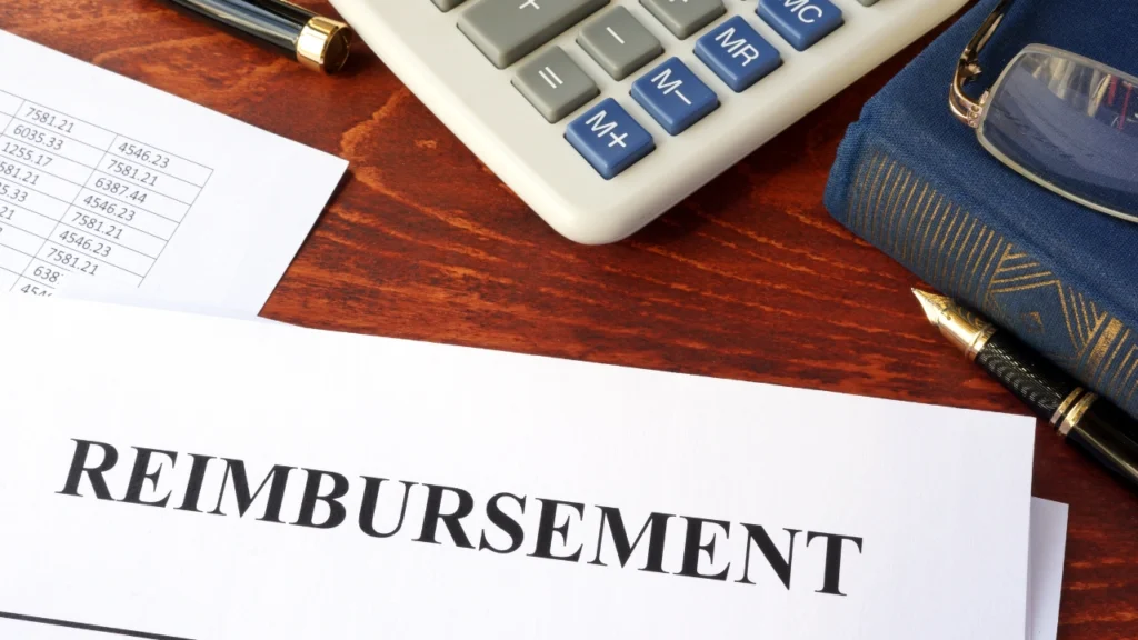 Can Accident Reimbursement Be Claimed? Image shows a reimbursement document, calculator, and pen on a wooden desk.