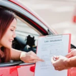 A woman in a red car reviews a clipboard with a Car Insurance Template form handed to her by another person.
