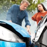 Two people inspect a car accident, raising the question: do insurance companies go after uninsured drivers for damages?