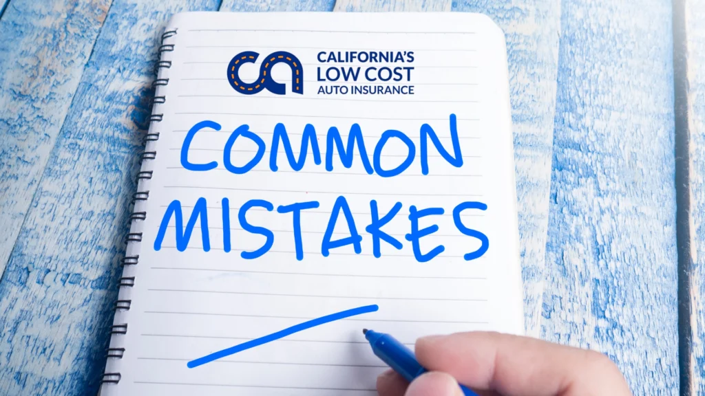 California Low Cost Auto Insurance Program notebook with handwritten text reading "Common Mistakes" on a blue wooden table.