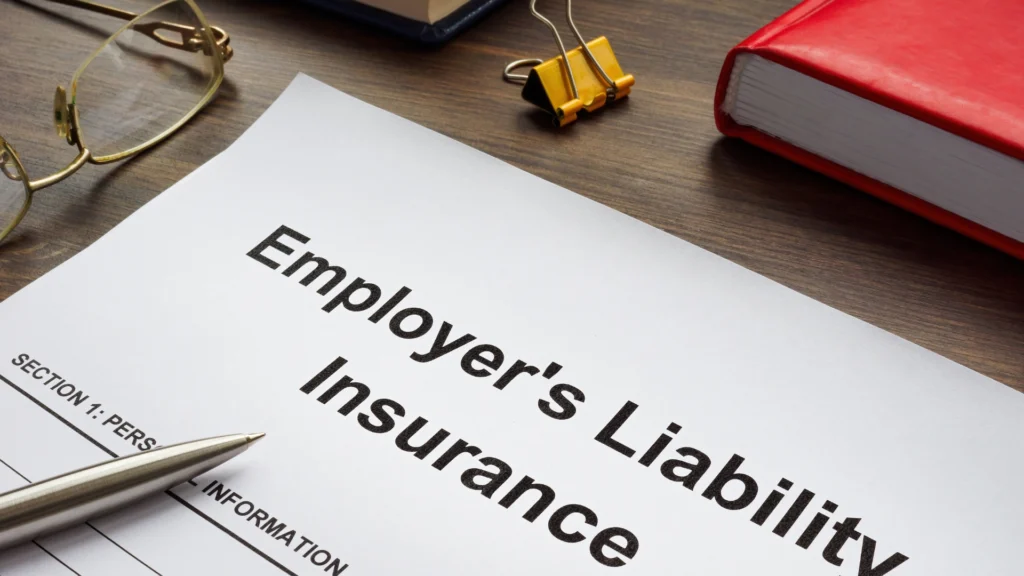 Employer's liability insurance document on desk with pen and binder, related to property damage liability in workplace coverage.