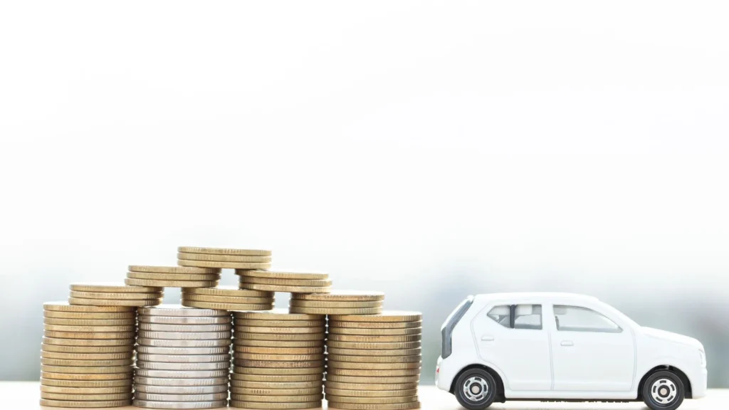 Toy car beside stacked coins symbolizing affordable rates with Remco auto insurance.